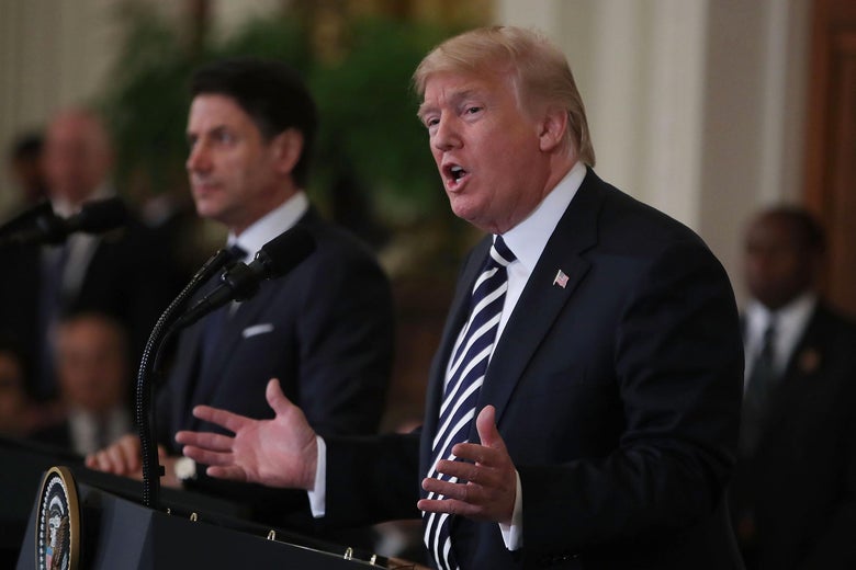 Donald Trump speaks at a podium beside Italian Prime Minister Giuseppe Conte.